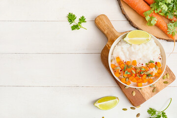 Bowl with boiled rice and pumpkin on table