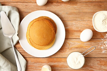 Tasty pancakes with ingredients on table