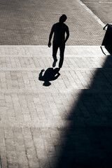 The silhouette of a guy with glasses, who rises up a concrete staircase to the top, creating an...