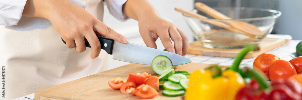 Wall mural Asian woman is preparing healthy food vegetable salad at light kitchen Cooking At Home and healthy food concept
