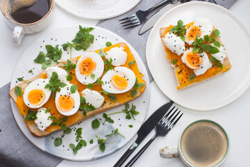 Toasted bread with pumpkin puree, cream cheese, green onion, herbs and boiled eggs for healthy lunch or breakfast.