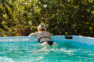 woman at the pool swimming alone, looking and smiling