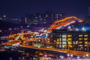 Fototapeta na wymiar 街中を走る高速道路とヘッドライトの光の河