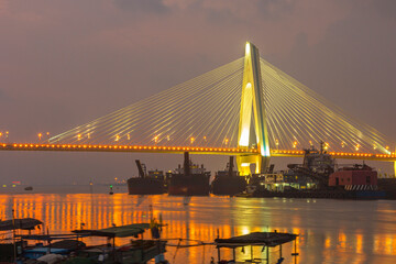 Obraz premium A bridge crosses the sea at night in hainan, China.