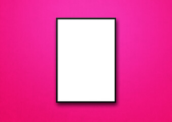 Black picture frame hanging on a pink wall