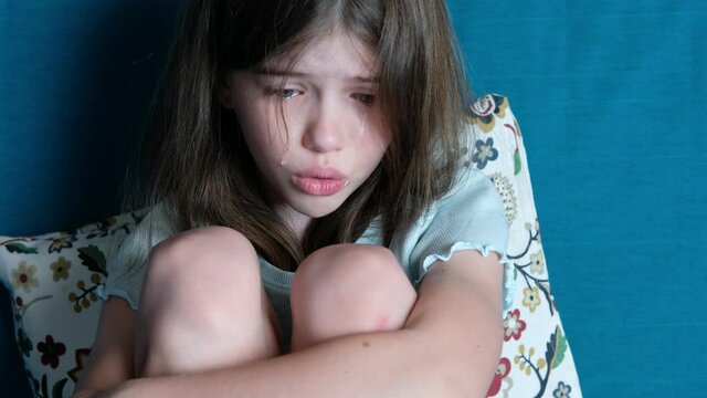 little girl swears with parents, protests, cries, tears on her cheeks