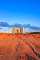 Tall buildings on red earth.