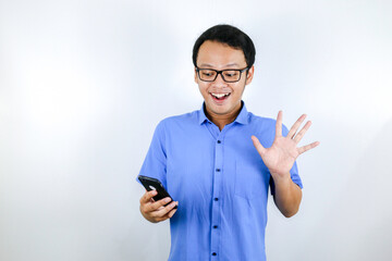 Young asian man shocked and happy when he looking smartphone