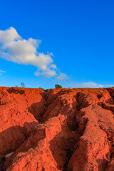 Fototapeta premium The red land is under the blue sky and white clouds.