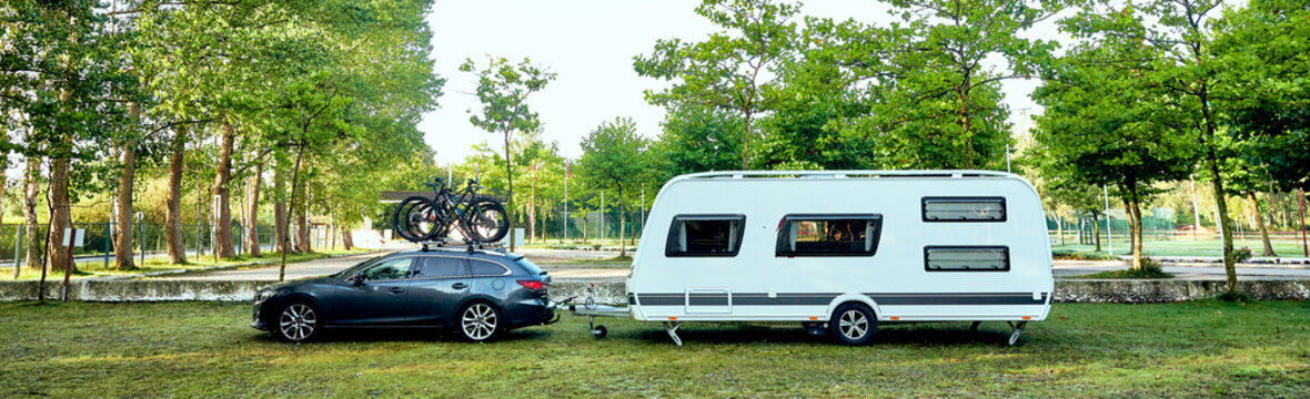 Wohnwagen Camping Gespann auf dem Weg in den Urlaub mit Fahrrädern auf dem Dach