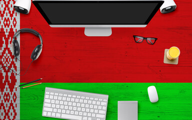 Belarus flag background with headphone,computer keyboard and mouse on national office desk table.Top view with copy space.Flat Lay.