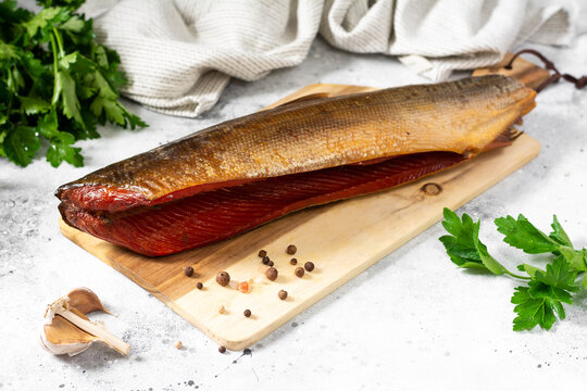 Sockeye salmon. Sockeye salmon on a serving board on a light gray kitchen table. Smoked sockeye salmon on a serving board