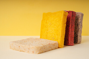 Colourful sliced of bread over yellow background.