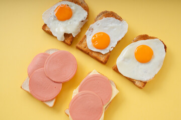 Home made organic sliced bread with fried eggs and ham cheese.