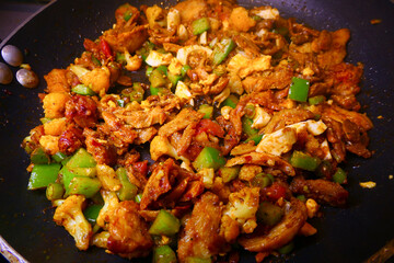 A frying pan with kebab meat and fresh onions.