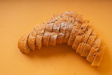 Sliced of loaf bread over orange background.