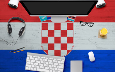 Croatia flag background with headphone,computer keyboard and mouse on national office desk table.Top view with copy space.Flat Lay.