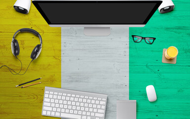 Cote D'Ivoire flag background with headphone,computer keyboard and mouse on national office desk...