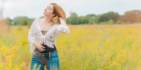 Fototapeta na wymiar Nice young woman in Bohemian fashionable style, outdoor portrait at field, Redhead girl in Boho style at meadow, fashionable details
