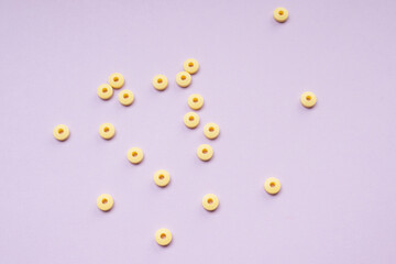 Yellow medicine pills circle shape over light purple background.