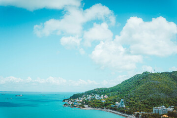 Obraz premium Panoramic coastal Vung Tau view from above, with waves, coastline, streets, coconut trees and Tao Phung mountain