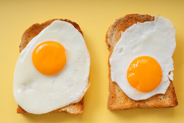 Two home made organic sliced bread grill with fried eggs on top.