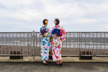 海沿いを散策する浴衣の女性
