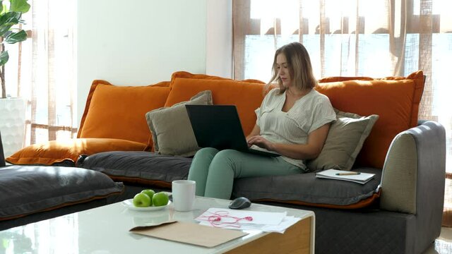 Female worker type text on laptop keyboard. Office home space background. Small business concept. Working from apartment in living room. Idea came concept