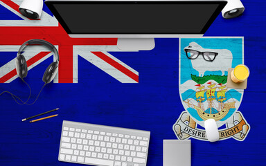Falkland Islands flag background with headphone,computer keyboard and mouse on national office desk table.Top view with copy space.Flat Lay.