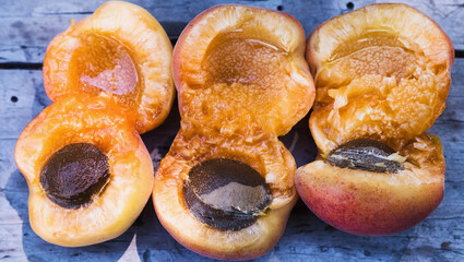 Juicy apricots with pits lie as a background