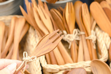 Wooden spoon and forks on sales with other wooden utensils kitchenware on display shelf selling in the Sunday market