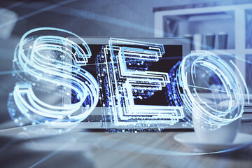 Multi exposure of table with computer and seo drawing hologram. Search optimization concept.