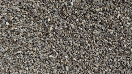 The texture of stone gravel gray. Stone rubble gray poured pile close-up.