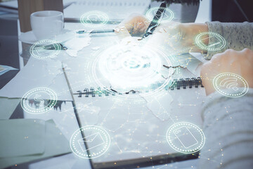 Social network theme hologram over hands taking notes background. Concept of global international people connect. Double exposure