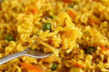 Fork holding spicy fried instant noodles,close up , selective focus.