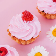 cupcake with pink frosting and raspberries