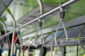 grey plastic hand holder in a city bus . inside the transport