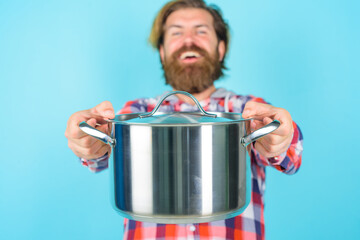 Man with saucepan. Selective focus. Happy man chef with pot. Saucepan. Cooking. Kitchenware. Cooking utensils. Cooking vessels. Kitchen advertising.
