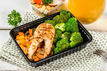 A piece of fried fish with broccoli in a container