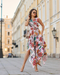 Young beautiful elegant tall slim woman with natural makeup and wavy brunete hair wearing colorful...