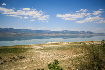 Reflection of the mountains in Burdur Lake. Wooden pier on the lake.