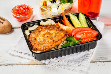 Cutlet with pasta, vegetables in a black container