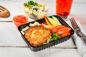 Cutlet with pasta, vegetables in a black container
