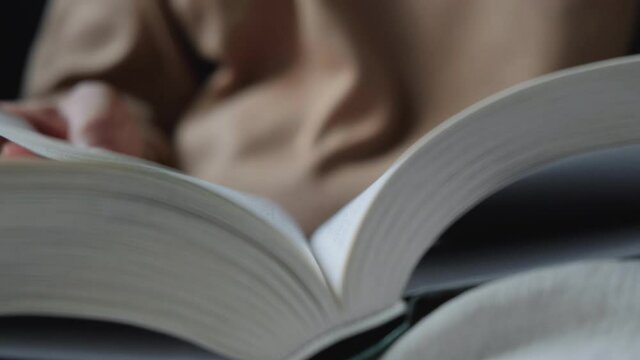 A Young Indian Woman Reading A Book And Turning The Page