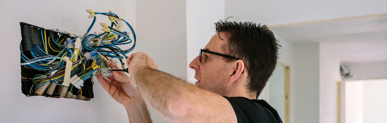 Obraz premium Electrician working on the electrical installation of a house