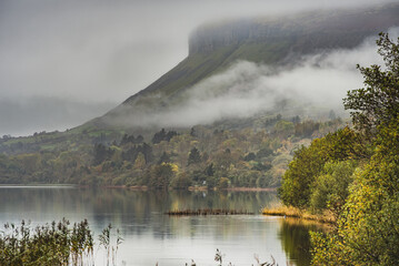 Low clouds above Glencar Lough (lake) with the iconic Benbulbin mountain rising in the background conveys relax, calm and joyful concept. Environmental illustration - County Sligo, Ireland