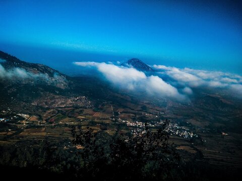 A bird's eye view of human civilization beside a hill.