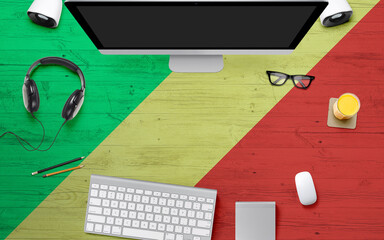 Republic Of The Congo flag background with headphone,computer keyboard and mouse on national office desk table.Top view with copy space.Flat Lay.
