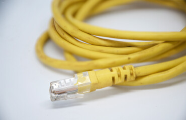 The plug of the yellow modem cable is rolled into a white scene.