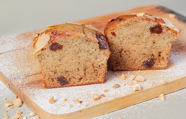 Banana cake dessert or banana bread placed on a wooden plate, with almonds and sprinkled with flour, decorated to look beautiful as a delicious food.